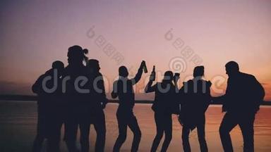团体<strong>青年</strong>舞蹈家在<strong>日</strong>落时在海滩上举行派对
